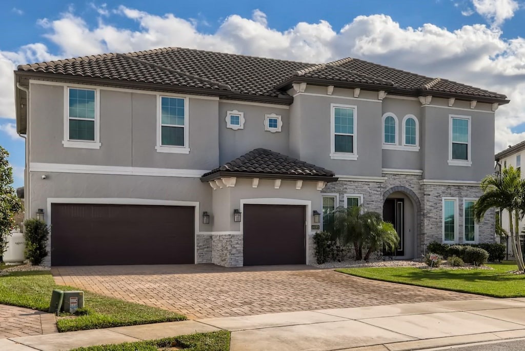 mediterranean / spanish-style house with a front yard and a garage