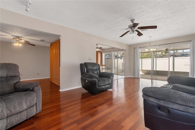 living room featuring hardwood / wood-style floors, a textured ceiling, and a notable chandelier