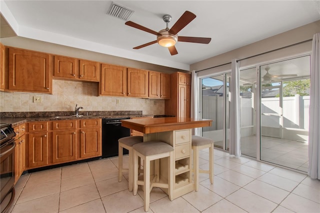 kitchen featuring dishwasher, light tile patterned flooring, a kitchen breakfast bar, and sink