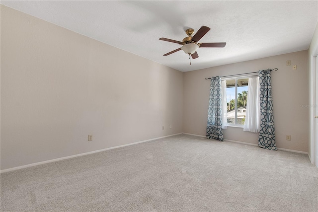 empty room featuring light carpet, a textured ceiling, and ceiling fan