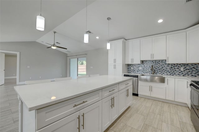 kitchen featuring white cabinetry, dishwasher, sink, decorative light fixtures, and lofted ceiling