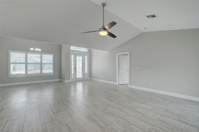 empty room featuring ceiling fan with notable chandelier, a healthy amount of sunlight, and lofted ceiling