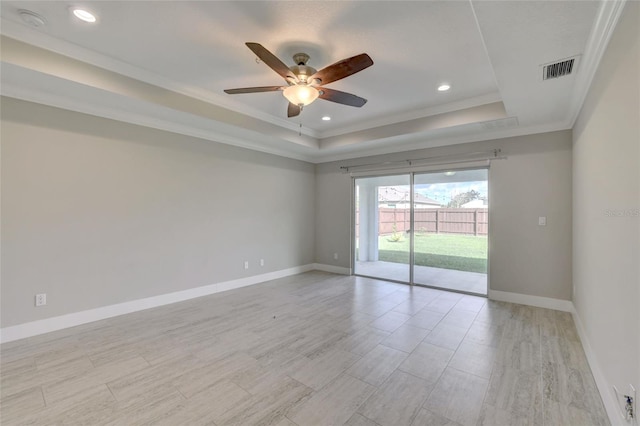 empty room with light hardwood / wood-style flooring, a raised ceiling, ceiling fan, and crown molding