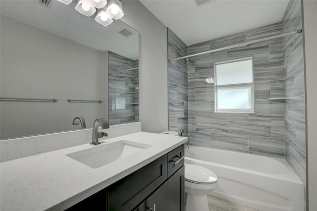 full bathroom with hardwood / wood-style floors, vanity, toilet, and tiled shower / bath