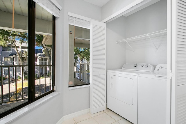 laundry room featuring washer and dryer and light tile patterned flooring