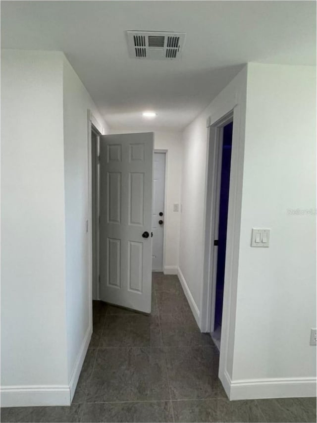 hallway with dark tile patterned floors