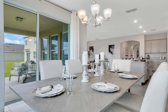 dining room with light tile patterned floors and a notable chandelier