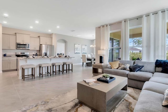 living room featuring light tile patterned flooring and a chandelier