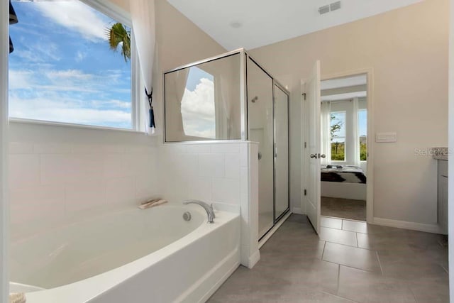 bathroom featuring tile patterned flooring and shower with separate bathtub