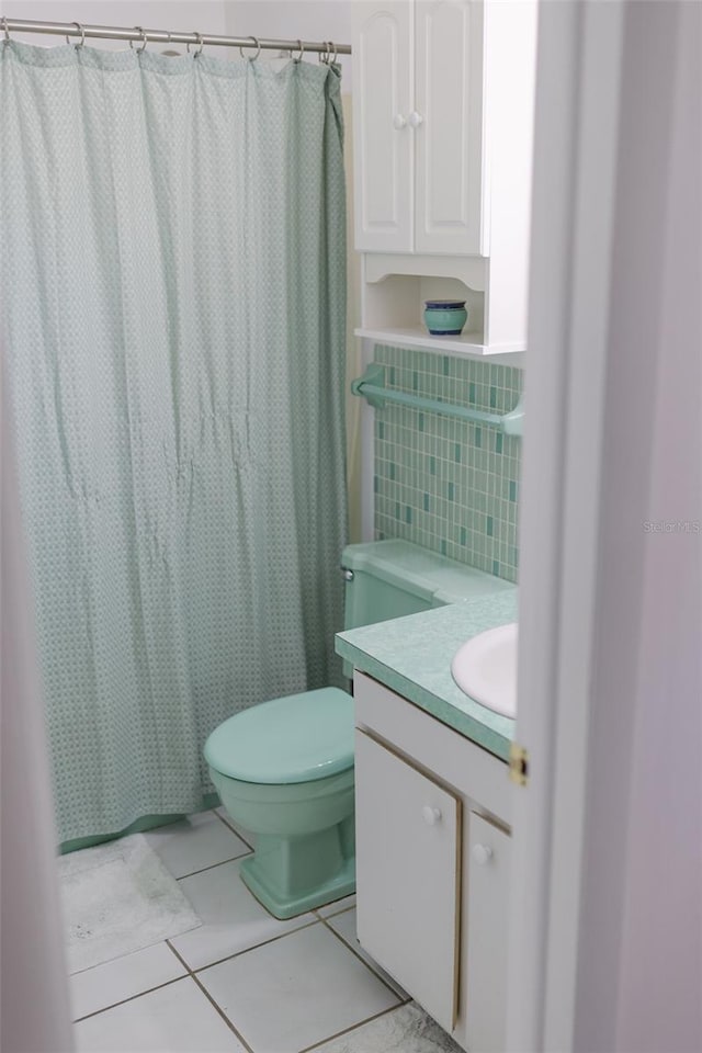 bathroom featuring tile patterned flooring, vanity, a shower with shower curtain, and toilet