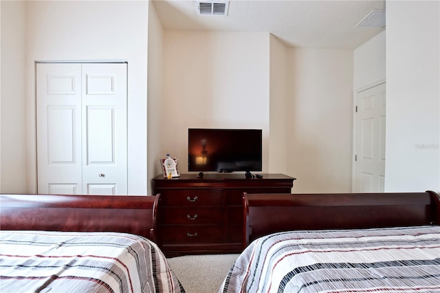 carpeted bedroom featuring a closet and a textured ceiling