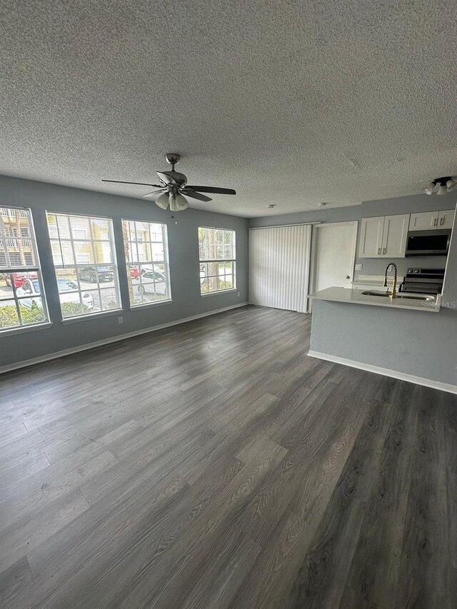 1023 S Hiawassee Rd Unit 4022, Orlando, FL 32835 - unfurnished living room featuring dark wood-style floors, a textured ceiling, a sink, baseboards, and a ceiling fan