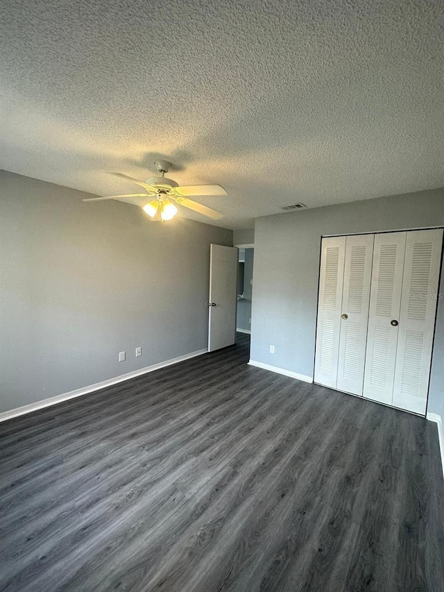 1023 S Hiawassee Rd Unit 4022, Orlando, FL 32835 - unfurnished bedroom with dark wood-style flooring, baseboards, a textured ceiling, and a closet