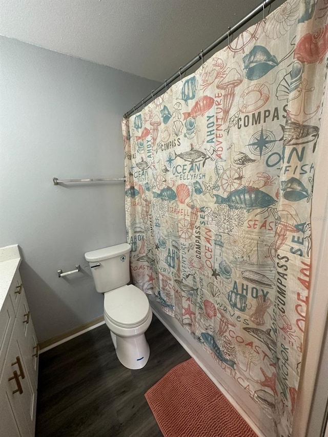 bathroom featuring curtained shower, vanity, wood-type flooring, and toilet