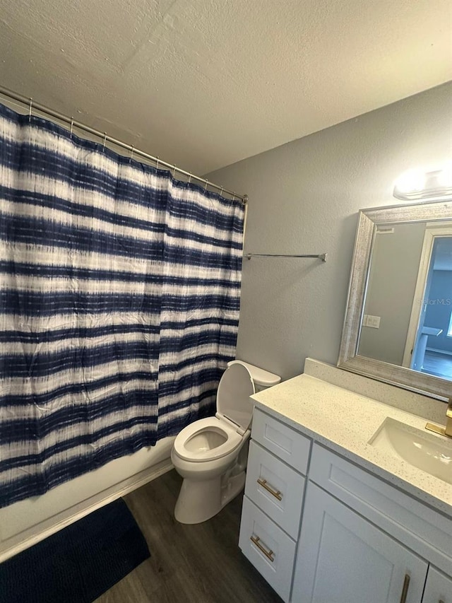 1023 S Hiawassee Rd Unit 4022, Orlando, FL 32835 - bathroom featuring vanity, wood finished floors, toilet, a textured ceiling, and shower / bath combo with shower curtain