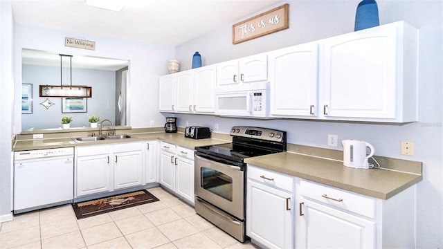 kitchen with pendant lighting, white appliances, sink, light tile patterned floors, and white cabinetry