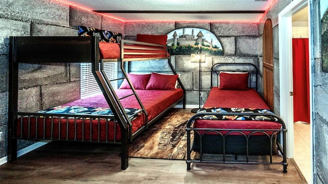 bedroom featuring wood-type flooring and a textured ceiling