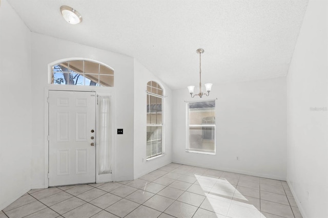 entrance foyer featuring lofted ceiling, a healthy amount of sunlight, and light tile patterned floors