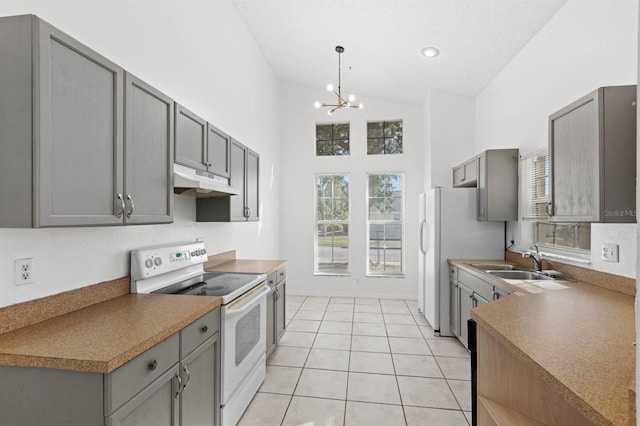 kitchen with white appliances, sink, light tile patterned floors, a chandelier, and gray cabinets