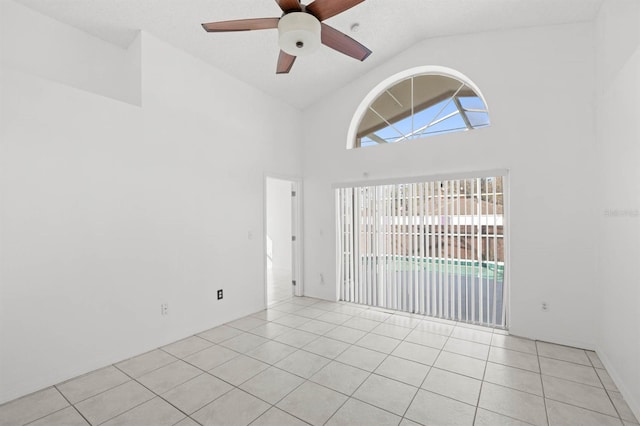 tiled spare room with ceiling fan and high vaulted ceiling