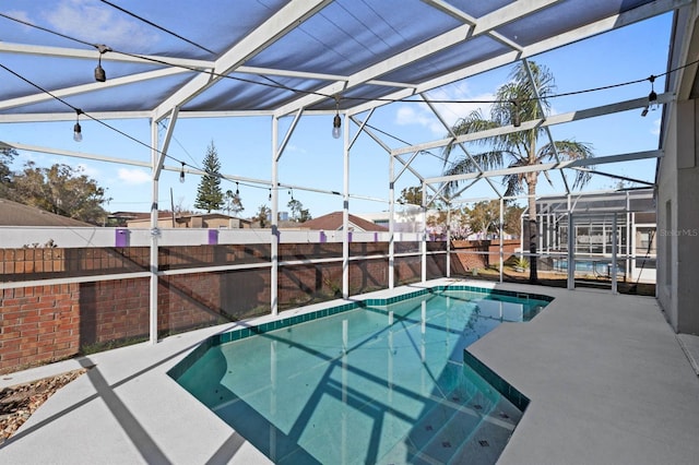 view of swimming pool with a lanai and a patio