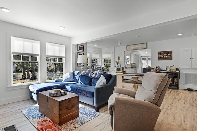 living room featuring a wealth of natural light and light hardwood / wood-style flooring