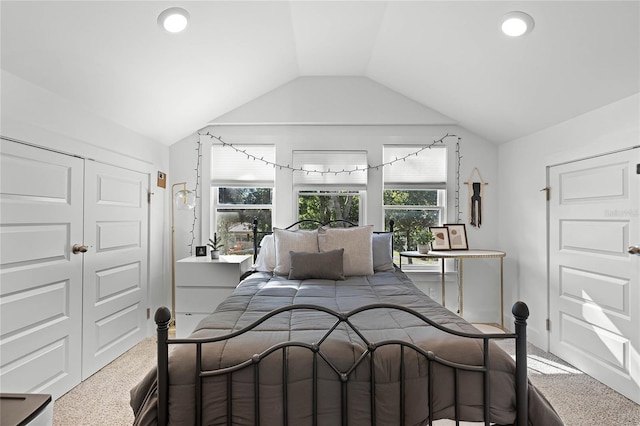 carpeted bedroom with a closet and lofted ceiling