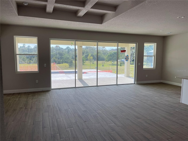 empty room with hardwood / wood-style floors, beamed ceiling, and coffered ceiling