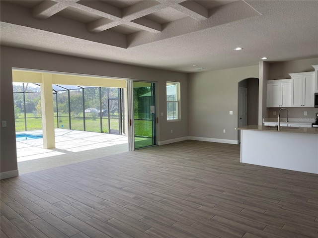 unfurnished living room with plenty of natural light, light hardwood / wood-style floors, and a textured ceiling