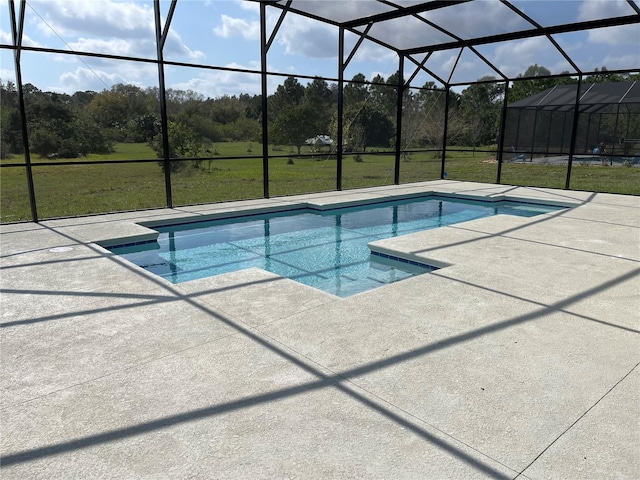 view of swimming pool featuring a lawn, a patio, and glass enclosure