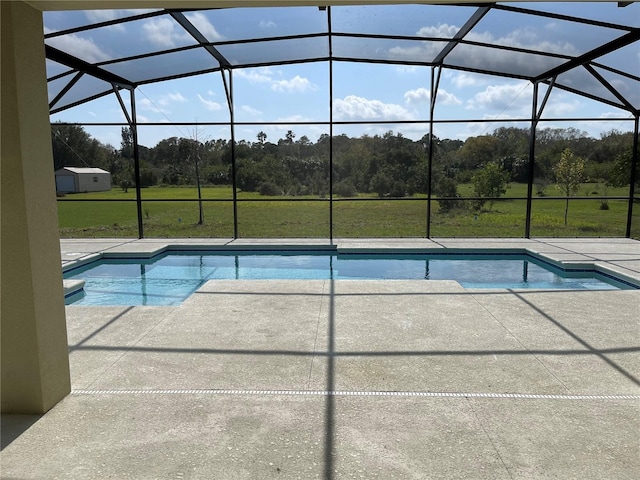 view of pool with a patio area, glass enclosure, and a lawn