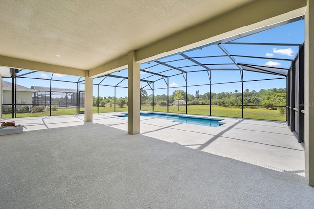 pool with a lawn, a patio, and glass enclosure