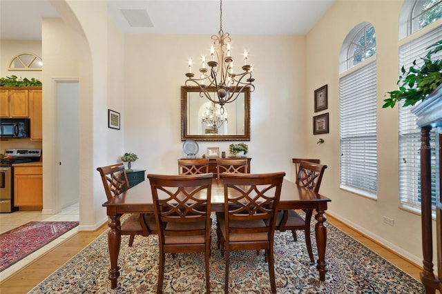 dining space featuring light wood-type flooring and a notable chandelier