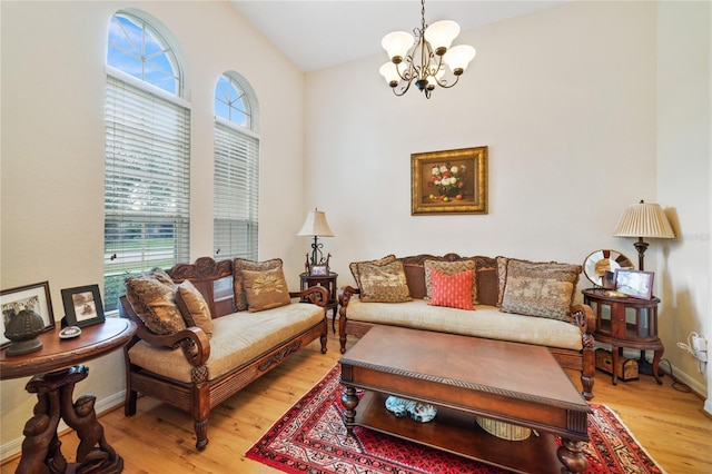 living room with light hardwood / wood-style flooring, lofted ceiling, and a notable chandelier