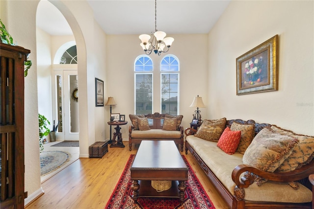 living room with an inviting chandelier and light hardwood / wood-style flooring