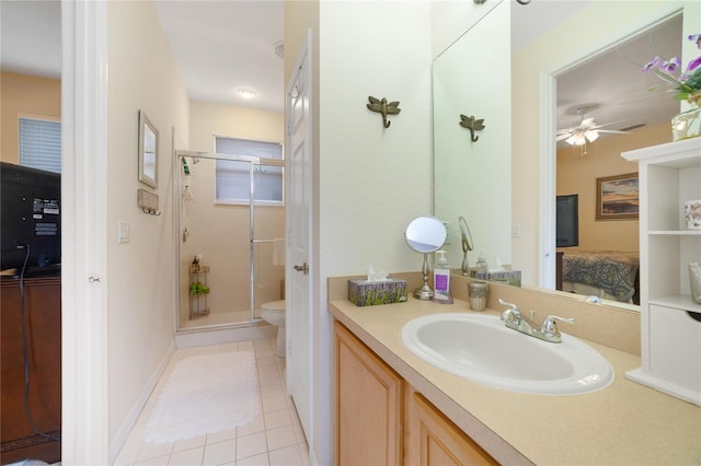 bathroom with tile patterned floors, walk in shower, vanity, ceiling fan, and toilet