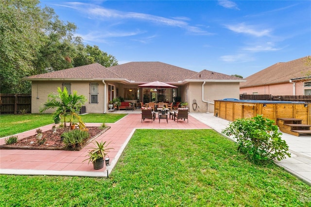 back of property featuring a patio area and a lawn