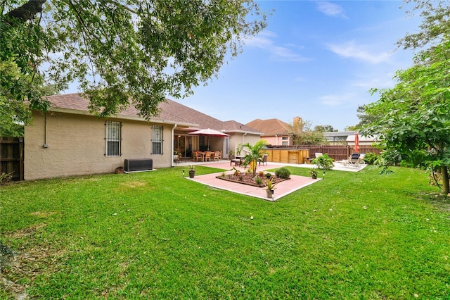 view of yard with central AC and a patio