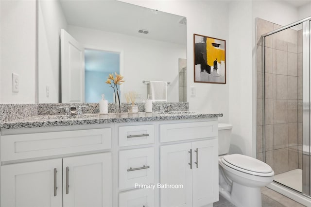 bathroom featuring vanity, toilet, and an enclosed shower