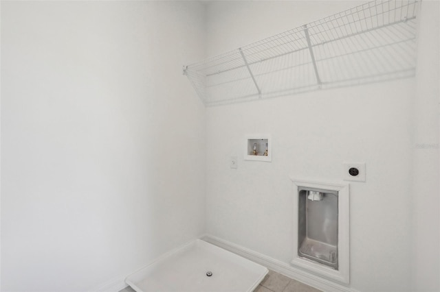 clothes washing area with hookup for an electric dryer, hookup for a washing machine, and light tile patterned flooring