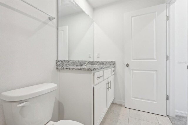 bathroom with tile patterned flooring, vanity, and toilet