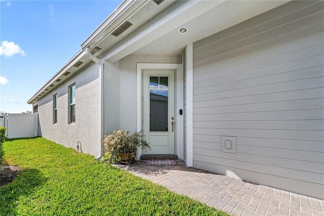 property entrance with a yard