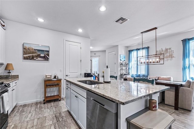 kitchen with white cabinets, sink, a center island with sink, dishwasher, and hanging light fixtures