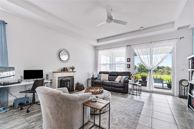 tiled living room featuring ceiling fan and a wealth of natural light