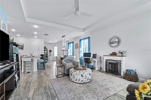 living room featuring ceiling fan and sink