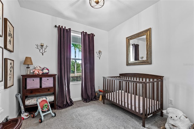 carpeted bedroom featuring a nursery area