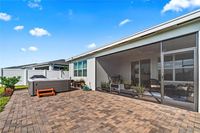 view of patio with a sunroom and a hot tub