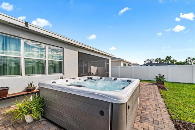 view of patio / terrace with a hot tub and a sunroom