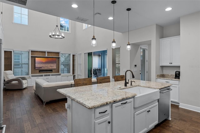 kitchen with white cabinetry, sink, dark hardwood / wood-style floors, plenty of natural light, and a kitchen island with sink