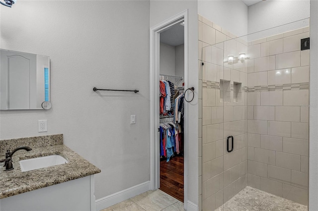 bathroom featuring vanity, hardwood / wood-style flooring, and a shower with door